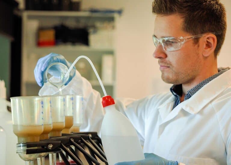 A researcher filtering sediment samples using a pump and water